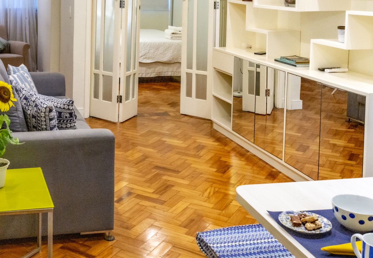 Sala de estar ampla e confortável com sofá, TV e mesa de jantar.